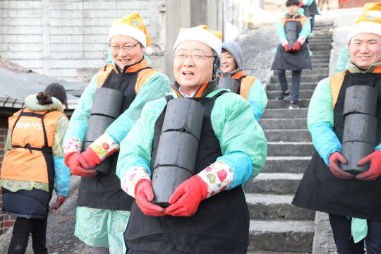 김창범 한화케미칼 사장(가운데)이 지난 16일 서울 상계동에서 '함께하는 사랑밭' 교사들과 임직원 50여명이 참가한 가운데 희망연탄 1만장과 쌀, 휴지 등 생필품을 어려운 이웃에게 전달하는 '따뜻한 방 만들기' 봉사활동을 하고 있다. 한화케미칼은 상·하반기 대표이사와 신입사원들이 매년 독거노인과 저소독층 가정등 도움의 손길이 필요한 곳을 찾아 봉사활동을 진행 중이다. <한화케미칼 제공>